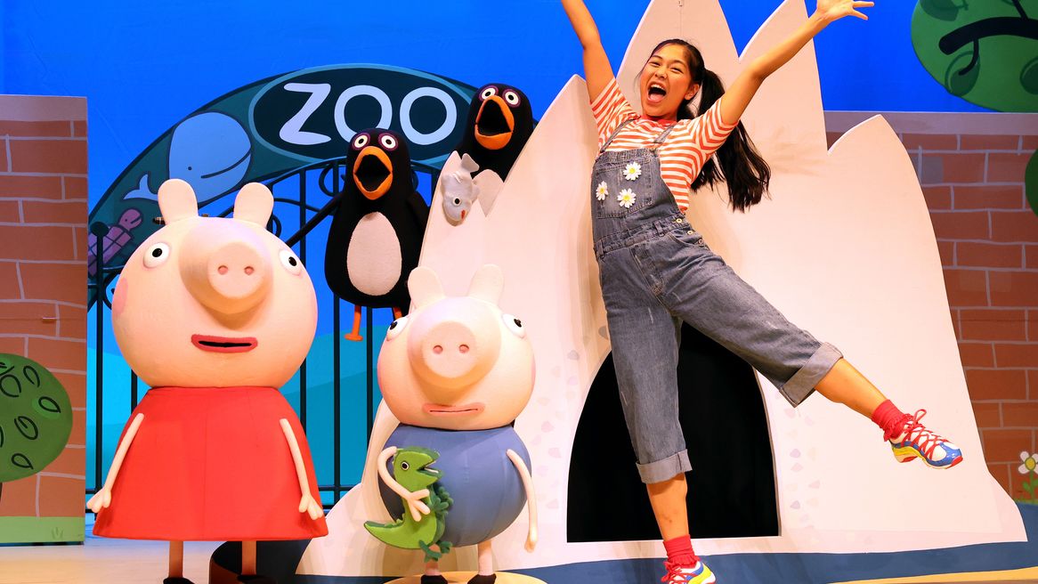 Animated pig characters in front of a zoo next to a girl dancing in front of a tent.