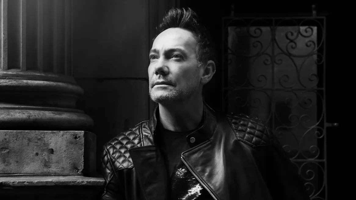 A greyscale image of Craig Revel Horwood in a leather jacket looking to the distance