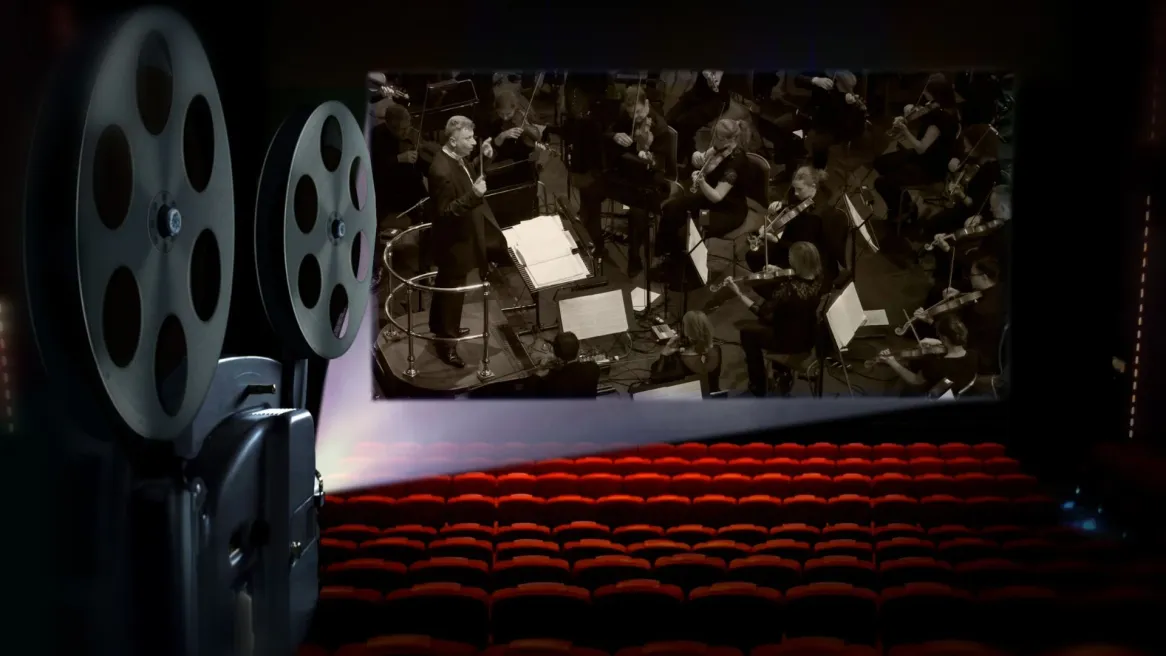 View of a theatre with an orchestra and old style cinema projector 