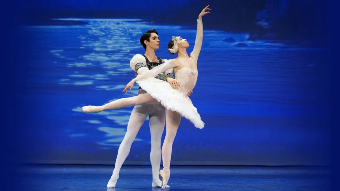 Male ballet dancer with his arms around female dancer En ponte dressed in a tutu 